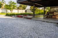 gravel area for driveways and parking in front of house with trees and walkways