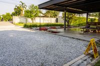 gravel area for driveways and parking in front of house with trees and walkways