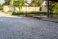 gravel area for driveways and parking in front of house with trees and walkways