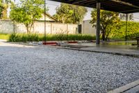 gravel area for driveways and parking in front of house with trees and walkways