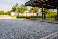 gravel area for driveways and parking in front of house with trees and walkways