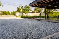 gravel area for driveways and parking in front of house with trees and walkways