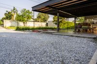 gravel area for driveways and parking in front of house with trees and walkways