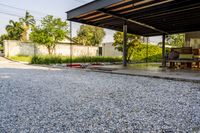 gravel area for driveways and parking in front of house with trees and walkways