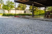 gravel area for driveways and parking in front of house with trees and walkways