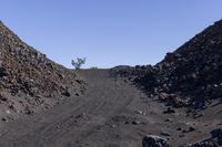 a gravel mountain with a sign sticking out of it's side next to rocks and trees