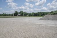 a pile of gravel is in the middle of a parking lot on a sunny day
