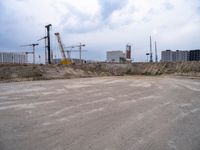 construction site with concrete structure, sky and sky line in background and construction equipment surrounding