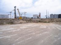 construction site with concrete structure, sky and sky line in background and construction equipment surrounding