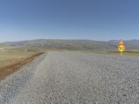 a road with gravel and a speed limit sign that says 65 degrees down on it