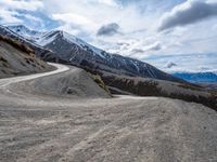 a gravel road in front of snowy mountain ranges on a partly cloudy day - zofran bielove