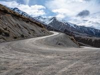 a gravel road in front of snowy mountain ranges on a partly cloudy day - zofran bielove