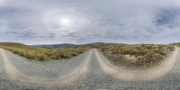 three small circles of gravel road that lead to two hills and grassy areas below them