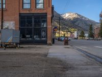 a red fire hydrant sitting in front of an old store window and building next to an open air field