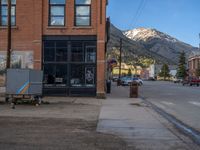 a red fire hydrant sitting in front of an old store window and building next to an open air field