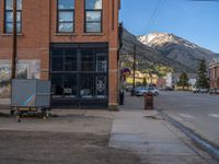 a red fire hydrant sitting in front of an old store window and building next to an open air field