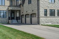 a gray and brick house on the corner of a sidewalk with grass in front of it