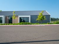 a building is painted gray outside with a white trimming and trees in the yard