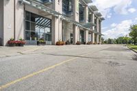 a gray fire hydrant in the middle of street with an office building behind it