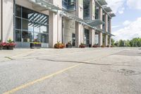 a gray fire hydrant in the middle of street with an office building behind it