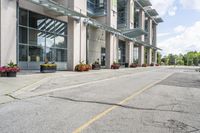 a gray fire hydrant in the middle of street with an office building behind it