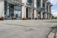 a gray fire hydrant in the middle of street with an office building behind it