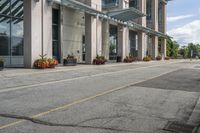 a gray fire hydrant in the middle of street with an office building behind it