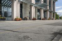 a gray fire hydrant in the middle of street with an office building behind it