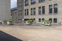 several gray stone vases sitting in front of some buildings and trees outside of a building