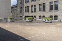 several gray stone vases sitting in front of some buildings and trees outside of a building