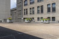 several gray stone vases sitting in front of some buildings and trees outside of a building