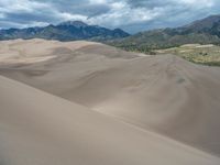 a lone skier climbs the sand dunes at great sand dunes national park, colorado in spring