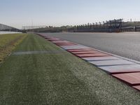 an empty track at a motorsports club with some red and white stripeing on it