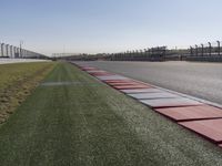 an empty track at a motorsports club with some red and white stripeing on it