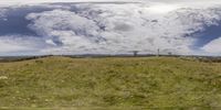 the grassy hill is under an ominous cloud formation, which allows to show off just how green a mountain looks