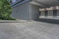 empty parking lot with concrete columns and windows on the roof in front of a skyscraper building