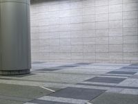 a modern restroom area with tiled floor, white columns and tiled walls and flooring