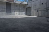 a person on a skateboard in an empty area between buildings and a walkway with a building