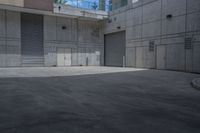 a person on a skateboard in an empty area between buildings and a walkway with a building