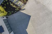 the concrete flooring is grey in color and the shadow of an umbrella is on top