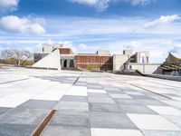 a building with some stairs and a large checkered tile floored area of brick