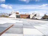 a building with some stairs and a large checkered tile floored area of brick