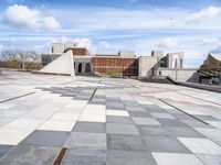 a building with some stairs and a large checkered tile floored area of brick