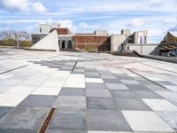 a building with some stairs and a large checkered tile floored area of brick