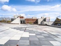 a building with some stairs and a large checkered tile floored area of brick