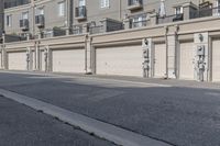 the building is stucco on the top floor and tall above the garage doors and the street is paved with gravel