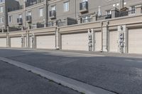 the building is stucco on the top floor and tall above the garage doors and the street is paved with gravel