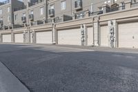 the building is stucco on the top floor and tall above the garage doors and the street is paved with gravel