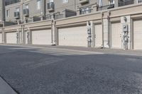 the building is stucco on the top floor and tall above the garage doors and the street is paved with gravel