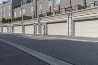 the building is stucco on the top floor and tall above the garage doors and the street is paved with gravel